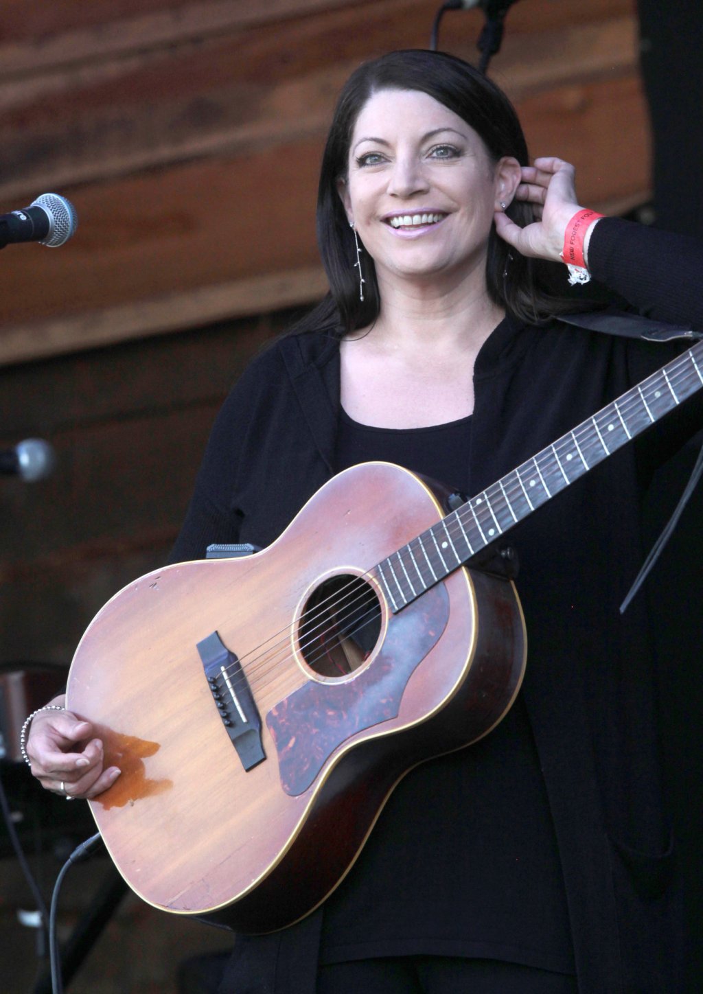 Edwina Hayes smiling with her acoustic guitar.